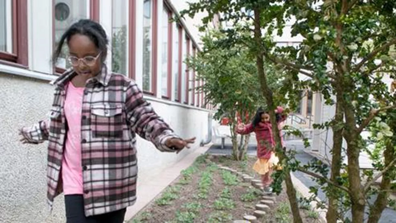Två barn som går balansgång i en lekpark