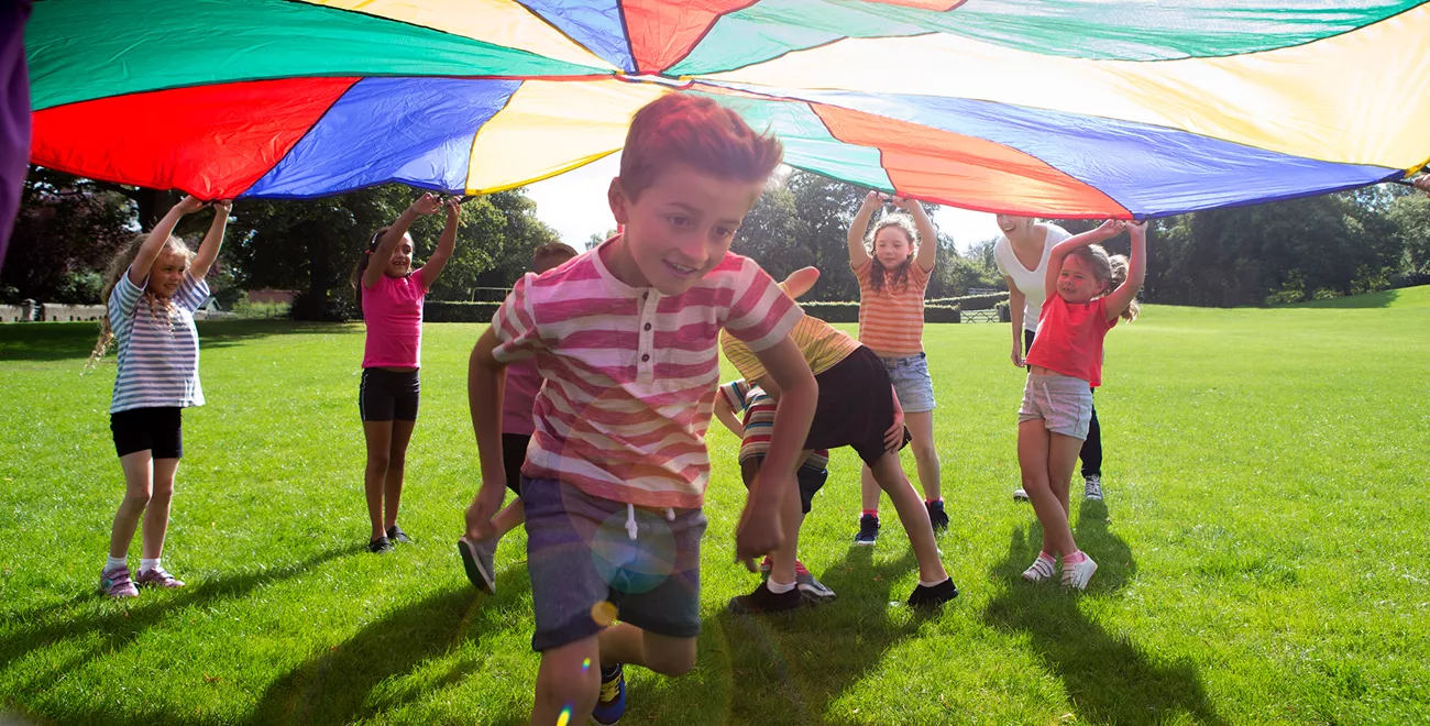 En bild på barn som är utomhus och leker.